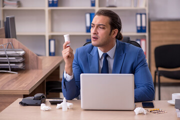 Young sick businessman employee suffering at workplace