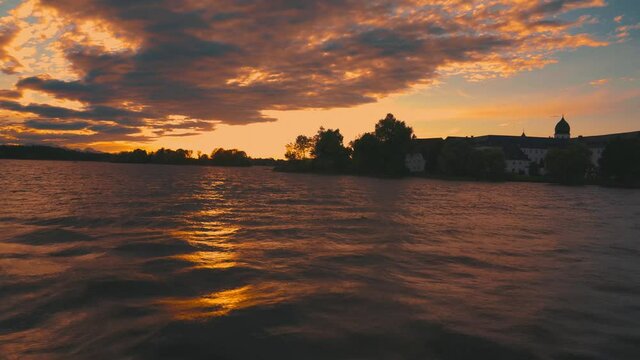 A boatride on the historic steam boat Ludwig Fessler, built in 1927, across the Chiemsee lake in Bavaria, home to King Ludwig II of Bavaria's Versaille replica castle on an island by sunset. 4K UHD