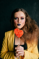 Portrait of young clown girl posing with sweet