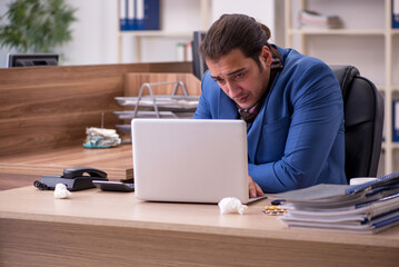 Young sick businessman employee suffering at workplace