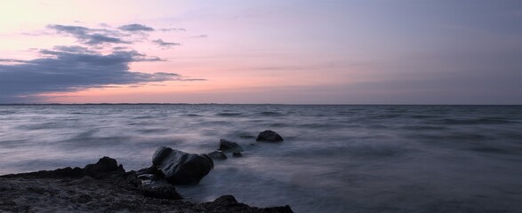 panoramic view to rocks by the sea at dawn, long exposure