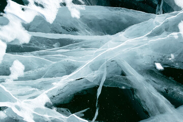 Abstract texture of craced ice and dark water at winter. Broken ice..