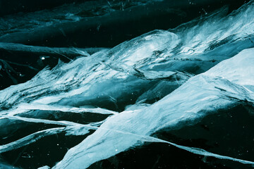 Abstract texture of craced ice and dark water at winter. Broken ice..