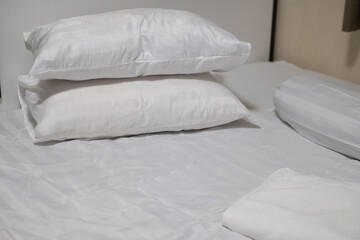 Close-up white bedding sheets and pillow with white towel.