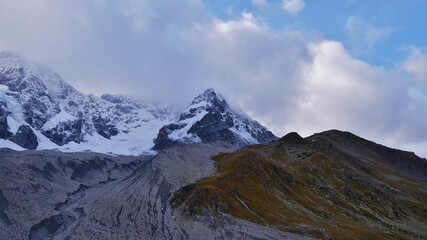 Panoramic view of the eastern flank of the majestic Ortler mountains in the Alps with glacier Suldenferner on a cloudy day in autumn near Sulden in South Tyrol, Italy in autumn season.