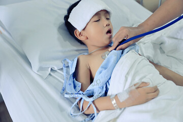 The boy was lying sick due to a lung infection. And the doctor was listening to the lungs with a stethoscope