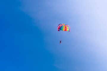 Fototapeta na wymiar Parasailing in blue sky. Sports, active leisure, travel, vacation concept