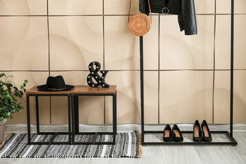 Stylish interior of modern hall with table and clothes rack