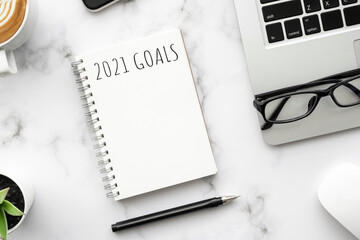 Note book with 2021 goals text on it to apply new year resolutions and plan.