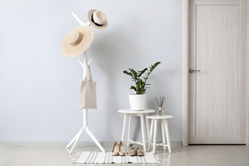 Stylish interior of modern hall with tables and clothes hanger