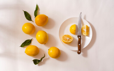 Fresh yellow lemons in a white plate on a white background. Half a lemon.