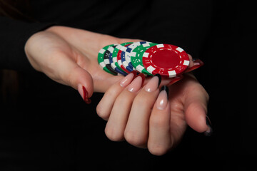 Gambling chips in hands on black background