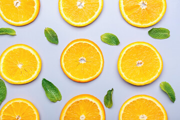 Fototapeta na wymiar Slices of orange fruit with mint on grey background