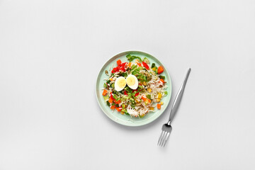 Plate of delicious rice salad with vegetables on light background