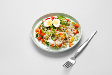 Plate of delicious rice salad with vegetables on light background