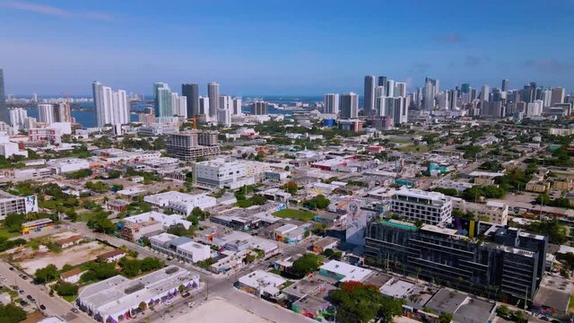 Aerial view over the Wynwood district, towards downtown skyscaper in Miami, Florida, sunny day, in USA  - tilt, drone shot