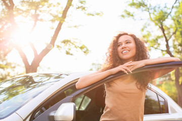 Happy African-American woman near car outdoors