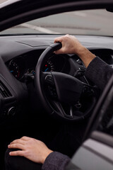 man sitting behind the wheel of a car close up