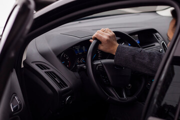 man sitting behind the wheel of a car close up