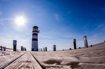 Lighthouse at Neusiedl am See with glowing sun and blue sky