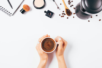 Home office flat lay with female hands holding cup of coffee