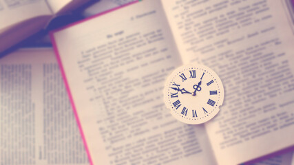 Dial with Roman numerals on books, top view