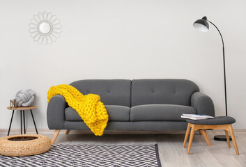 Interior of modern room with sofa and knitted plaid