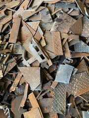 Metal waste, iron plates, industrial waste, close-up. Metal waste, embedded parts for concrete structures with reinforcement, iron plates, industrial waste at the construction site.