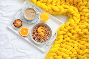 Tray with tasty breakfast on bed, top view