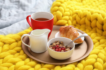 Tray with tasty breakfast on bed