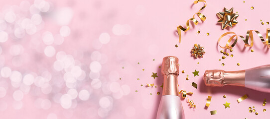 Long wide Christmas and New Year’s banner with rose Champagne bottles, golden decorations and...