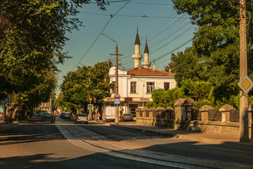 Fototapeta na wymiar Revolution street in the old district of the city of Yevpatoria, with old buildings and single-track tram tracks
