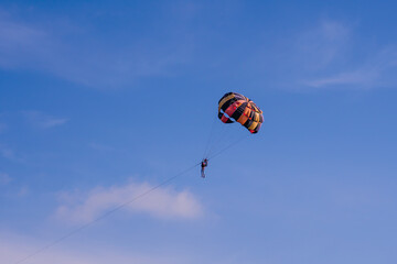 Parasailing in blue sky. Sports, active leisure, travel, vacation concept