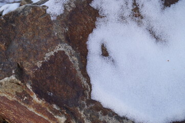 Close-up (macro photography) natural stone with snow. Can be used as background