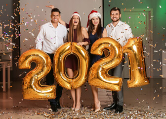 Fototapeta na wymiar Young people celebrating New Year at corporate party in office