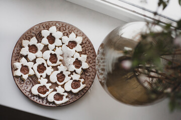 Homemade baked cookies with chocolate on a plate on white windowsill. To cook delicious quarantine at home.