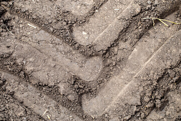 Texture soil. Trace from tractor wheel on ground. Agriculture background.