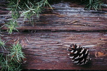 Fond en bois vieilli avec des branches de sapin et pomme de pin dans les angles - Arrière plan...
