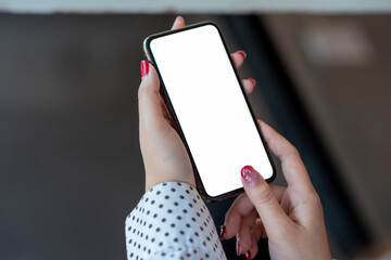 Mock up. image of woman holding mobile phone with blank white screen.