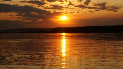 Summer sunset on the river in warm golden tones.      