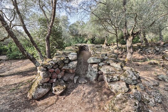 Ruins of a nuragic hut in the Santa Cristina archaeological park. Sardinia, Italy