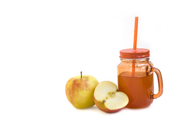 glass orange cup with apple juice with screw cap and tube in it and with apples lying next to the cup on white background