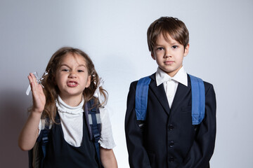 The boy and girl are now looking at the camera. They are wearing school uniforms. 