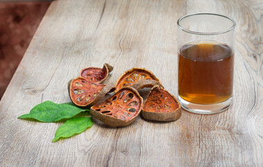 Dried bael fruit with their juice on table.