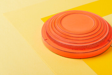 Clay target for skeet shooting against the colorful yellow background. Clay pigeon shooting. Copy space
