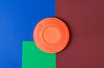 Clay target for skeet shooting against the colorful geometric background. Clay pigeon shooting. Copy space