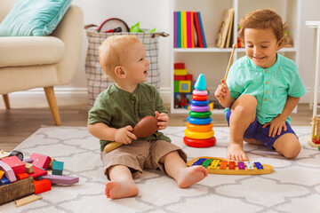 The little boys play with musical toys in kindergarten