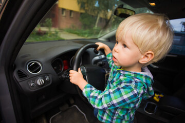 The boy imagines himself as a driver in a real car