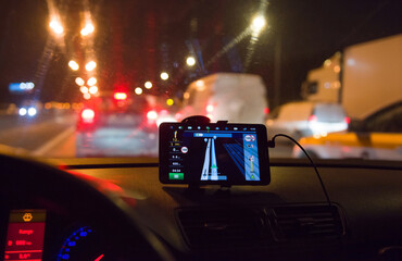 Tablet with a navigator in the car on the background of a night city