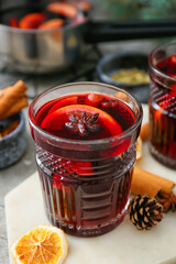 Glass of tasty mulled wine on table, closeup